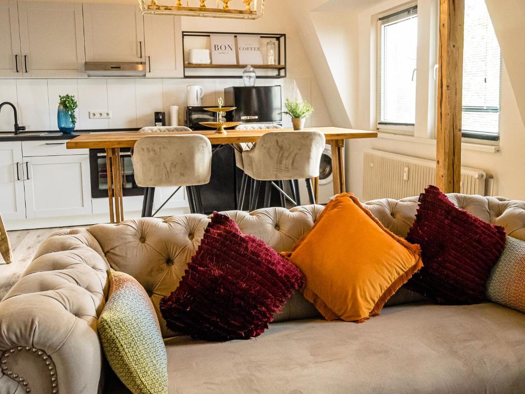 杜伊斯堡Fabelhafte Apartments zum wohlfühlen mit JUNIK Apartments的客厅配有带色彩缤纷枕头的沙发