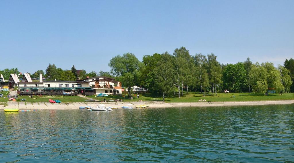Horní Soběšovice雅莉普莱斯塔酒店的一片带海滩和房屋的水域