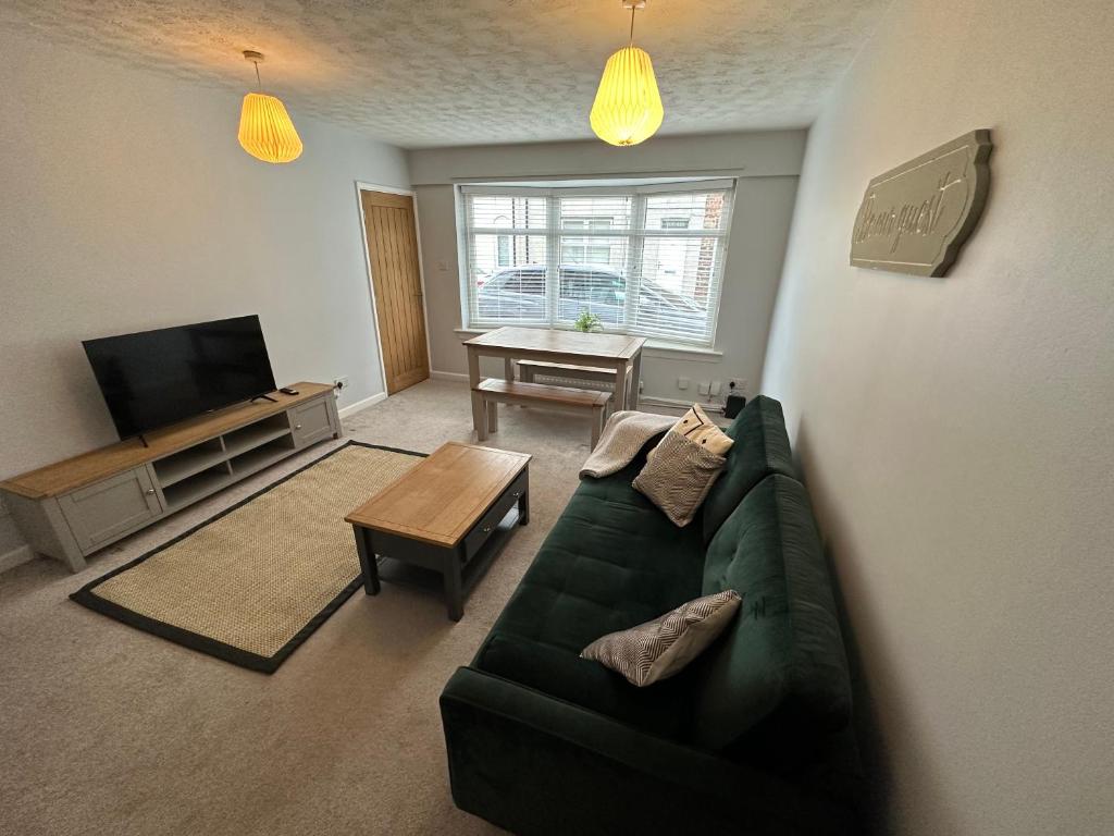 吉斯伯勒Cosy, 2 Bedroom Cottage in Guisborough Town Centre的客厅配有绿色沙发和桌子