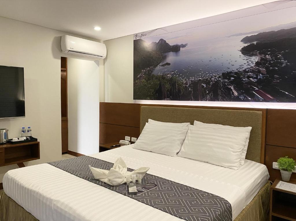 爱妮岛比尔旅游宾馆的酒店客房的墙上设有一张带照片的床。