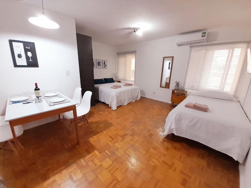 门多萨Mendoza Apartment的客房设有两张床、一张桌子和一张书桌。