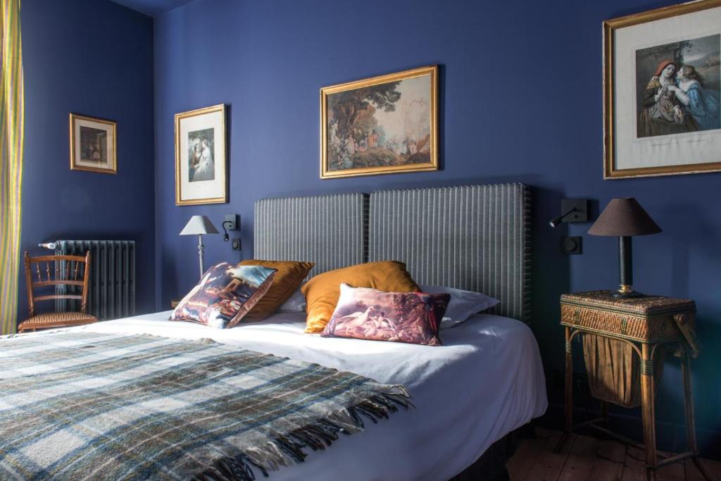 迪耶普La Villa Augustine的一间卧室拥有蓝色的墙壁,配有一张带枕头的床。