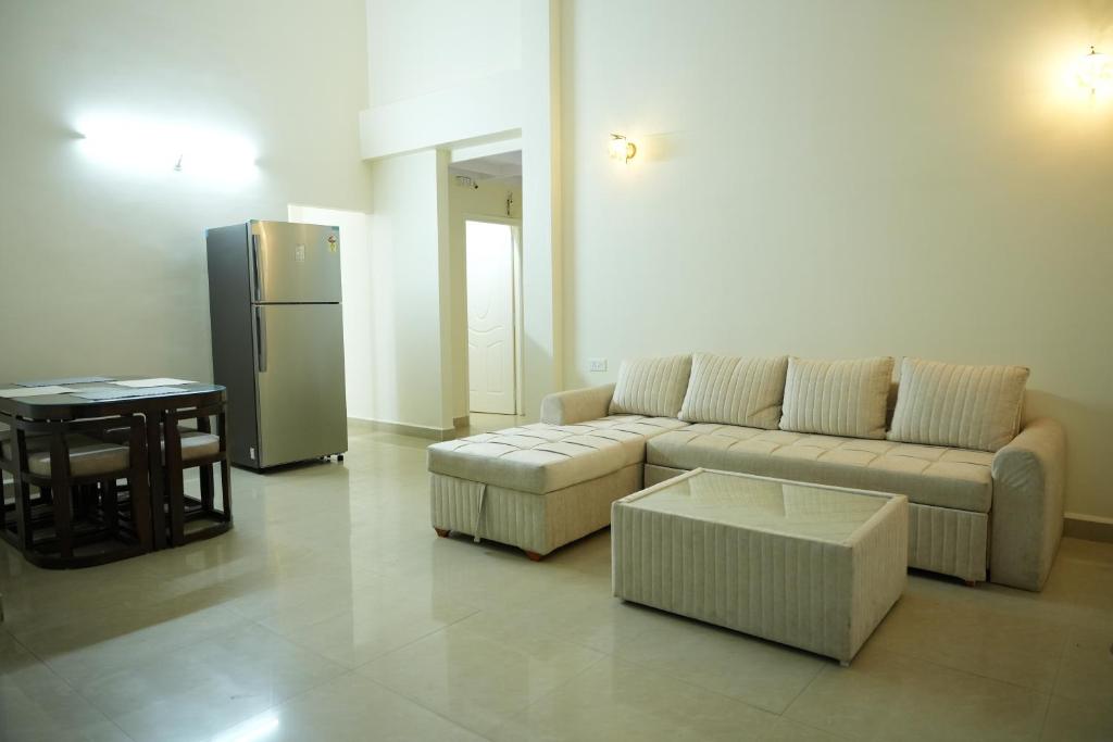 帕纳吉Shri Mahamaya的带沙发、桌子和冰箱的客厅