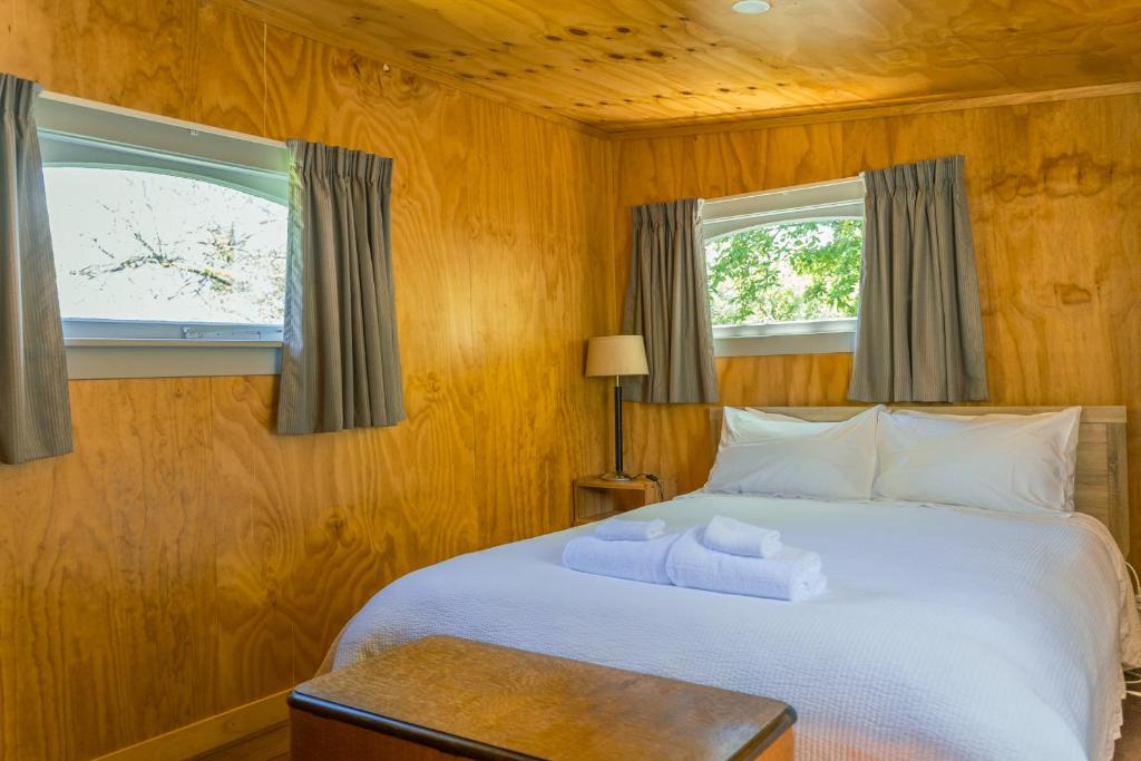 特卡波湖Mount Cook Station Huts的卧室配有白色床和2扇窗户