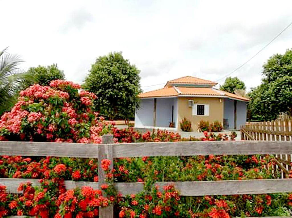 诺布里斯Pousada Canto das Araras - Vila Bom Jardim Nobres MT的花木围栏后面的房子