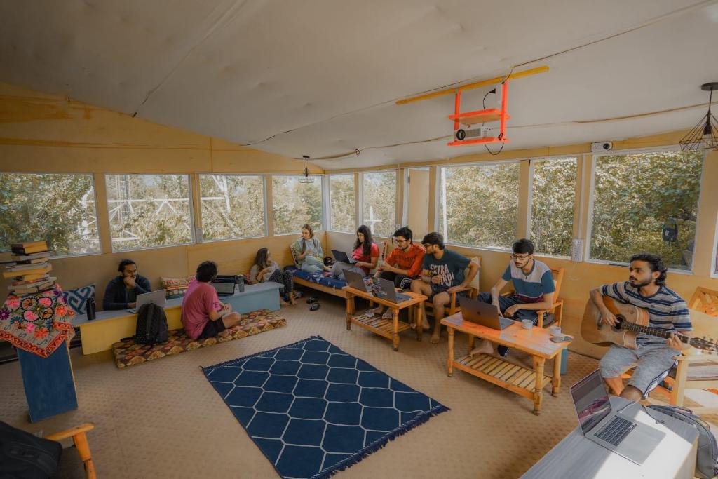 马拉里Mars Monkey Hostel & Cafe的一群人坐在一个笔记本电脑的房间
