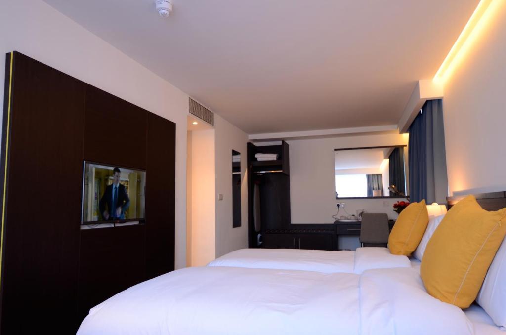 伦敦鹈鹕伦敦公寓酒店的酒店客房,设有两张床和镜子