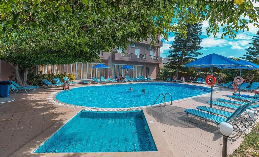 阿默达拉-伊拉克利翁卡斯特罗酒店的游泳池设有蓝色椅子,里面有人
