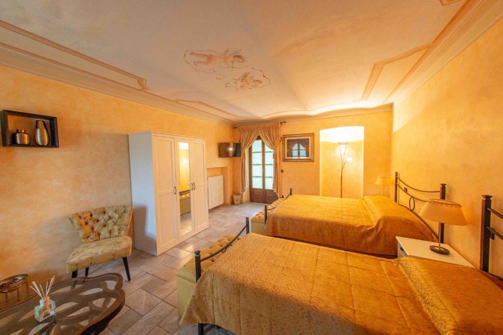 希尼奥Agriturismo Rihane的一间大卧室,配有两张床和椅子