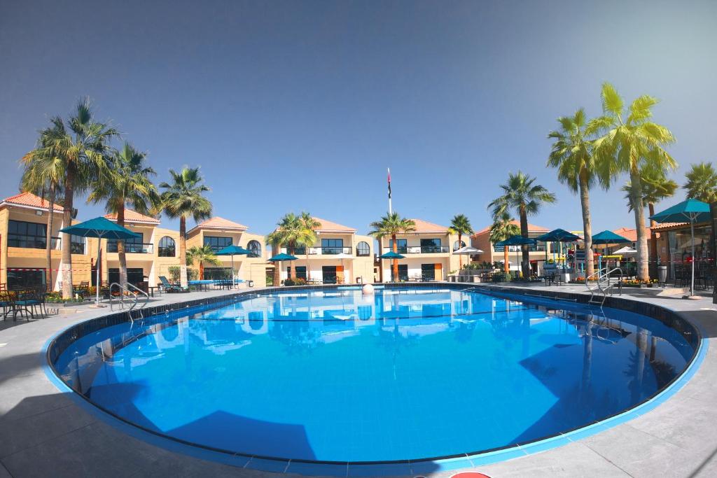 乌姆盖万帕尔马海滩Spa度假酒店的度假村内一个蓝色的大泳池