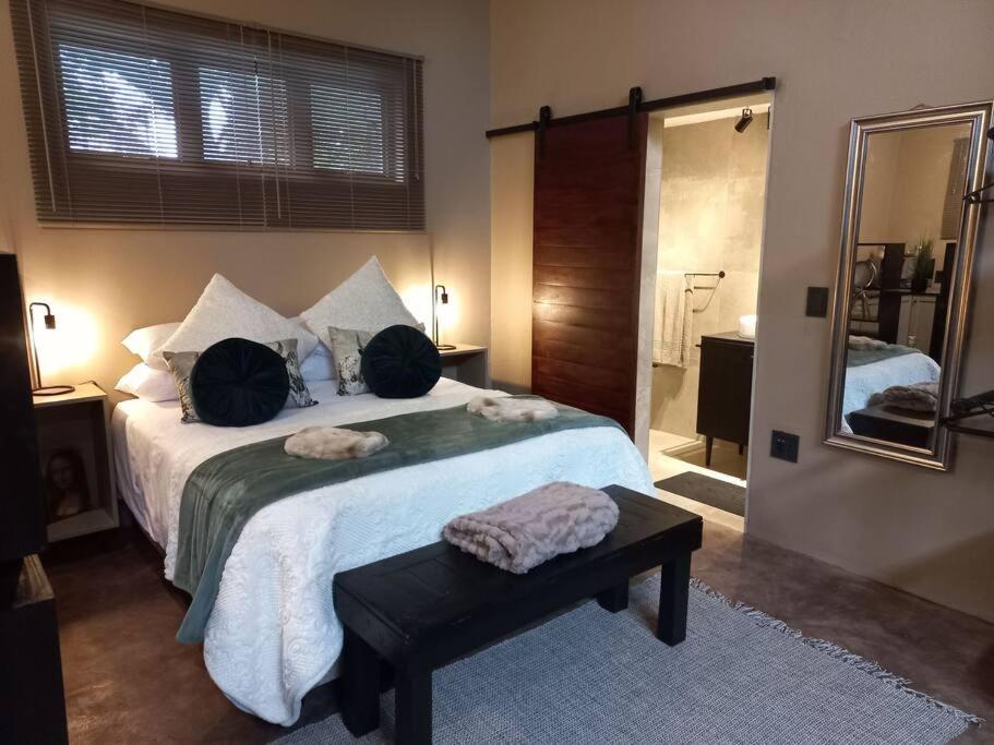 希尔克雷斯特Stacey's Cornerstone Studio Apartment的一间卧室配有一张大床和镜子