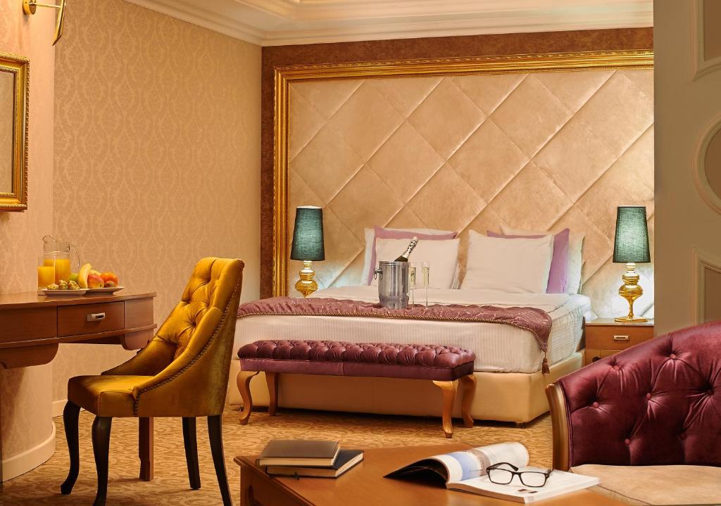 巴库剧院精品酒店的一间卧室配有一张床、一张桌子和一把椅子