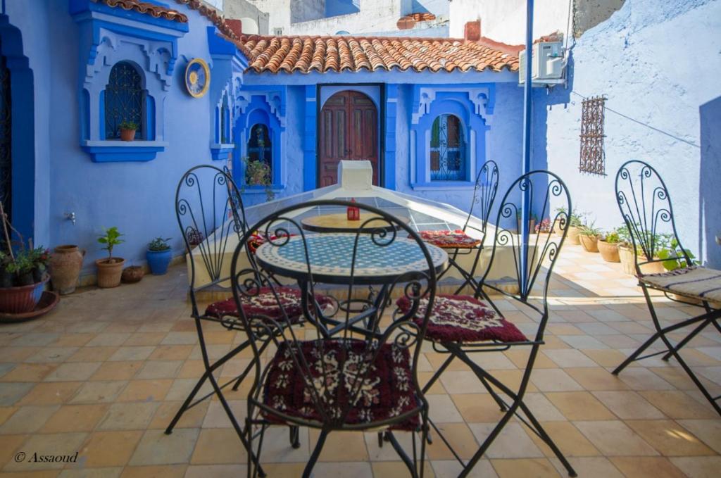 舍夫沙万Dar El Fanne的蓝色房子前面的一张桌子和椅子