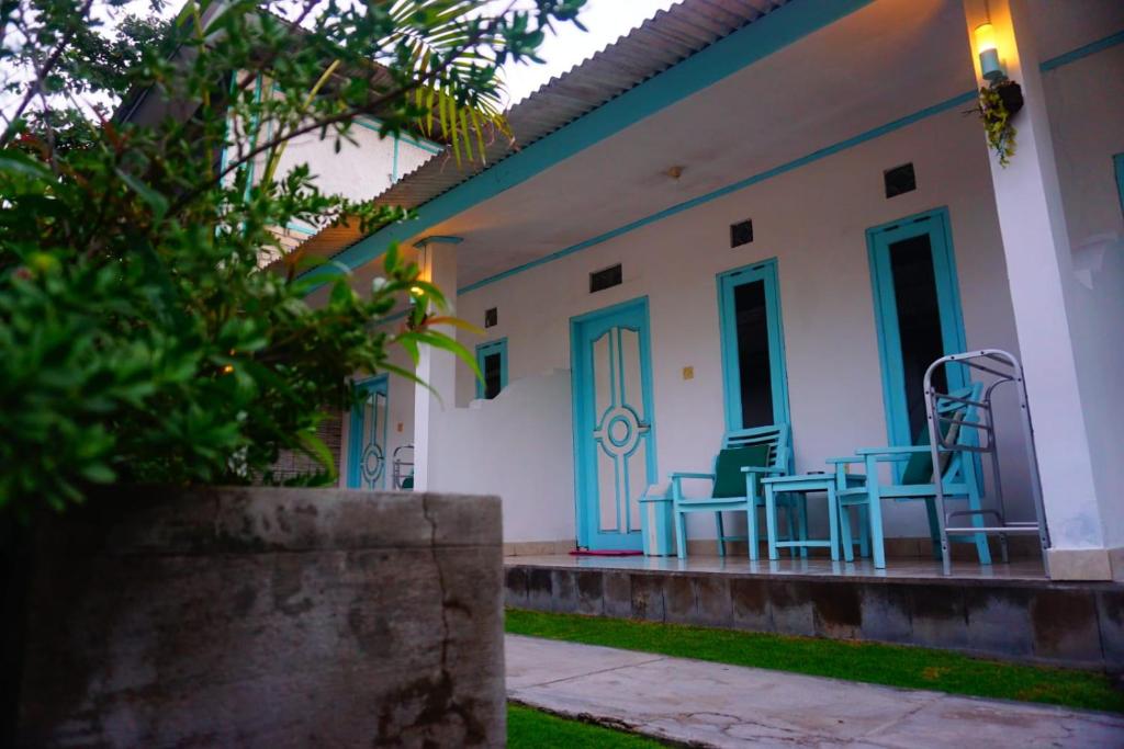 吉利特拉旺安玫瑰寄宿家庭旅馆的门廊上设有蓝色桌椅的房子
