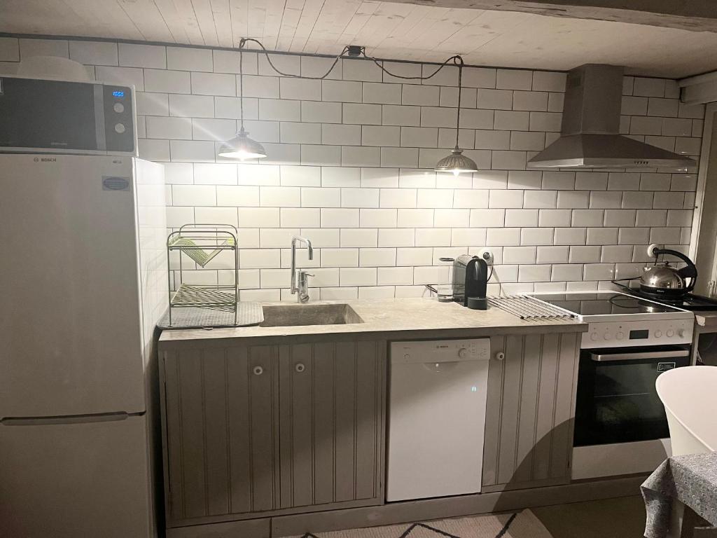 赫尔辛堡Studio Råå的厨房设有水槽和白色瓷砖墙。