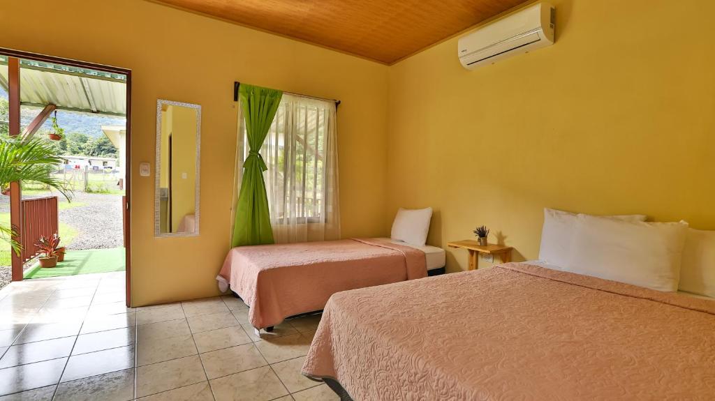 福尔图纳Chongos Place的酒店客房设有两张床和窗户。