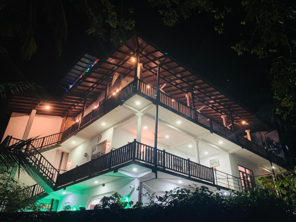 乌纳瓦图纳Hiru Resort Inn Unawatuna的白色房子,晚上设有阳台