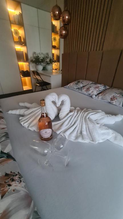 布拉戈耶夫格勒Апартамент Мегилукс 2的一张带两条毛巾和一瓶酒的床