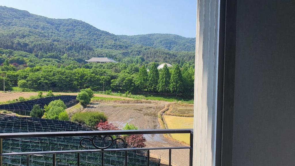 SejongGamseong House的享有田野和山脉美景的阳台。