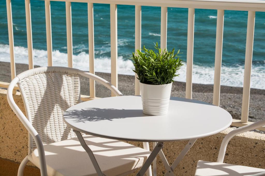 拉拉维塔El Cachalote Feliz的阳台上配有白色的桌椅,享有海景