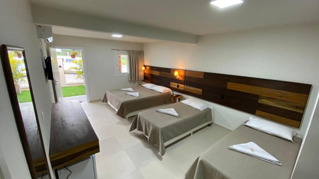 格拉瓦塔尔Pousada Quatro Estações的酒店客房设有两张床和一张桌子。