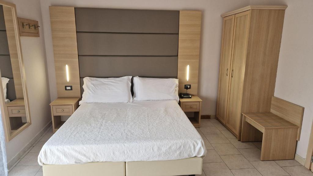 拉戈堡Hotel Trasimeno Bittarelli的一间卧室配有一张带2个床头柜的大床
