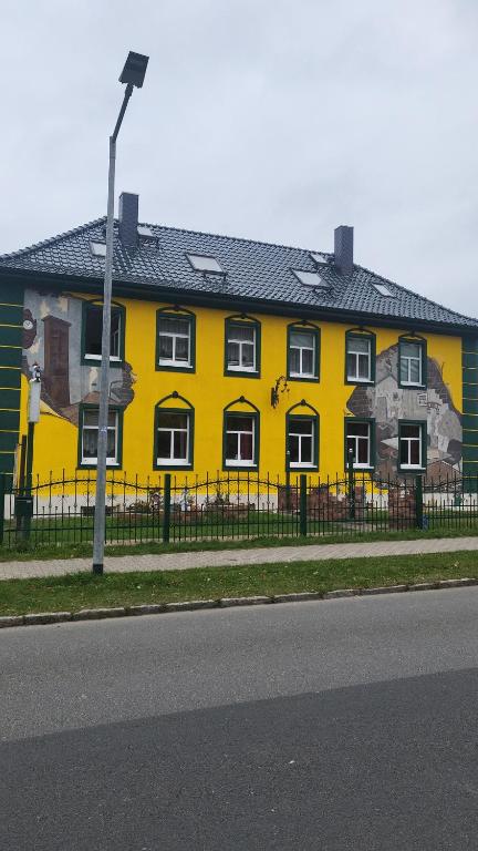 巴特多布兰珍妮特旅馆的黄色的建筑,在建筑的一侧画着画