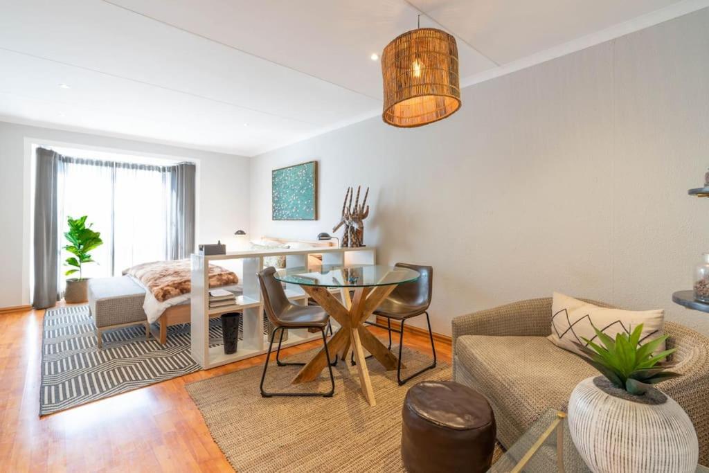 约翰内斯堡Modern apartment in culturally vibrant Melville 22的客厅配有桌子和沙发