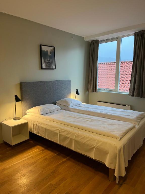 卑尔根City Hostel Bergen的卧室配有一张白色大床和两个窗户