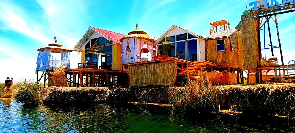 普诺Uros Lake Titicaca Lodge的水体上的房子