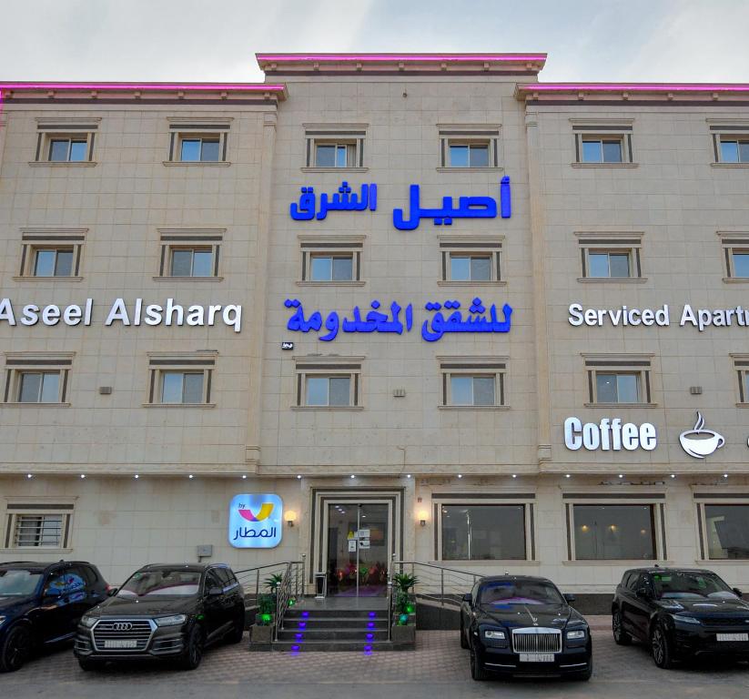 利雅德Aseel Alsharq Hotel的门前有车辆停放的酒店