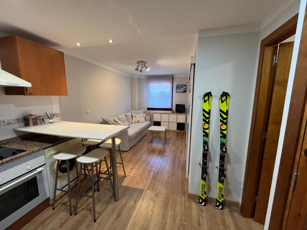 圣伊西德罗Precioso apartamento en San Isidro , ski , snow的厨房以及带墙上滑雪板的起居室。