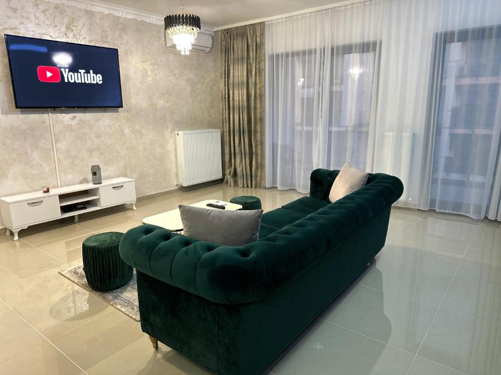 普洛耶什蒂Mrs Smart Luxury Apartament的客厅配有绿色沙发和电视