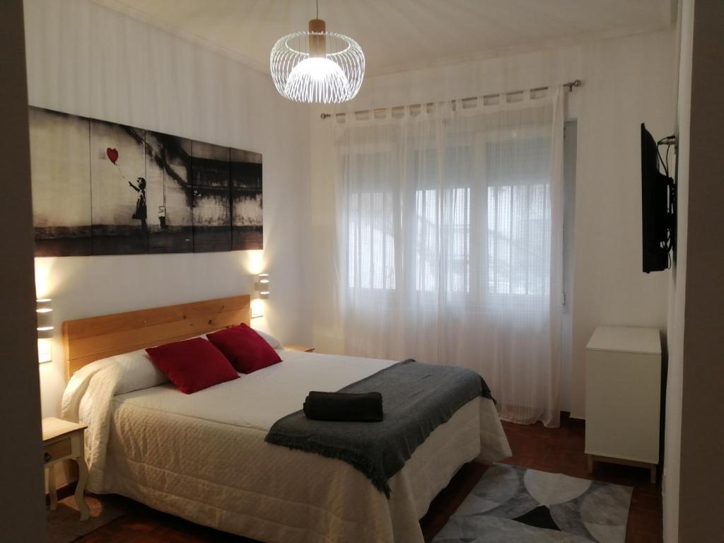 毕尔巴鄂Piso luminoso, amplio y tranquilo en Casco Viejo的一间卧室配有一张带红色枕头的大床