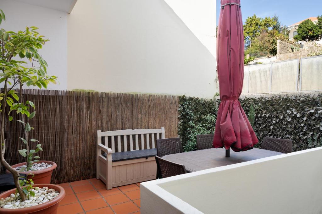 波尔图Refugio的庭院配有遮阳伞和桌椅。