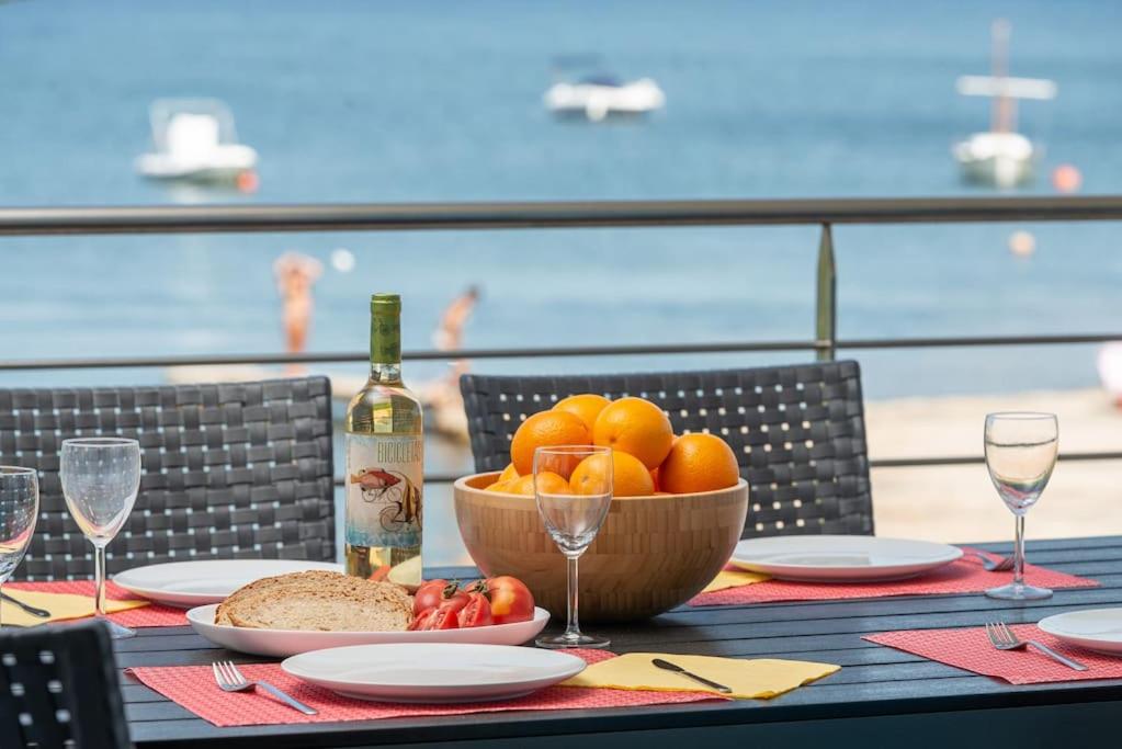 阿尔库迪亚S'Embat sea views的一张桌子,上面放着一碗水果和一瓶葡萄酒