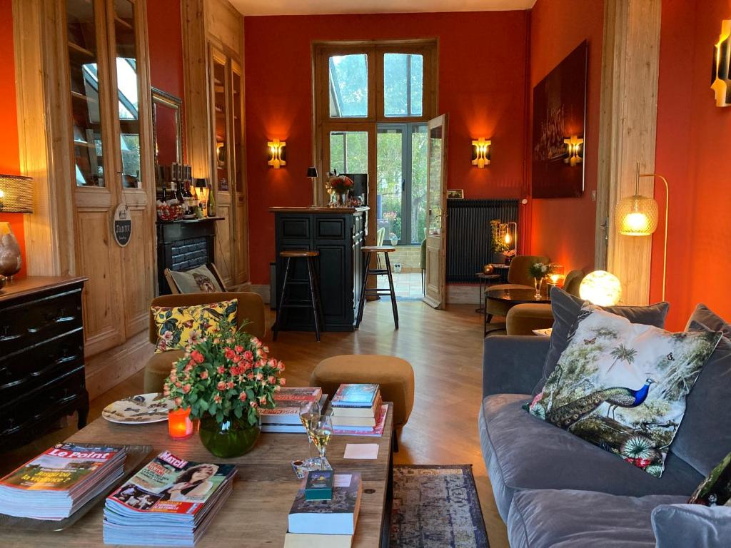 布尔堡Les Berges的客厅配有沙发和桌子及书籍