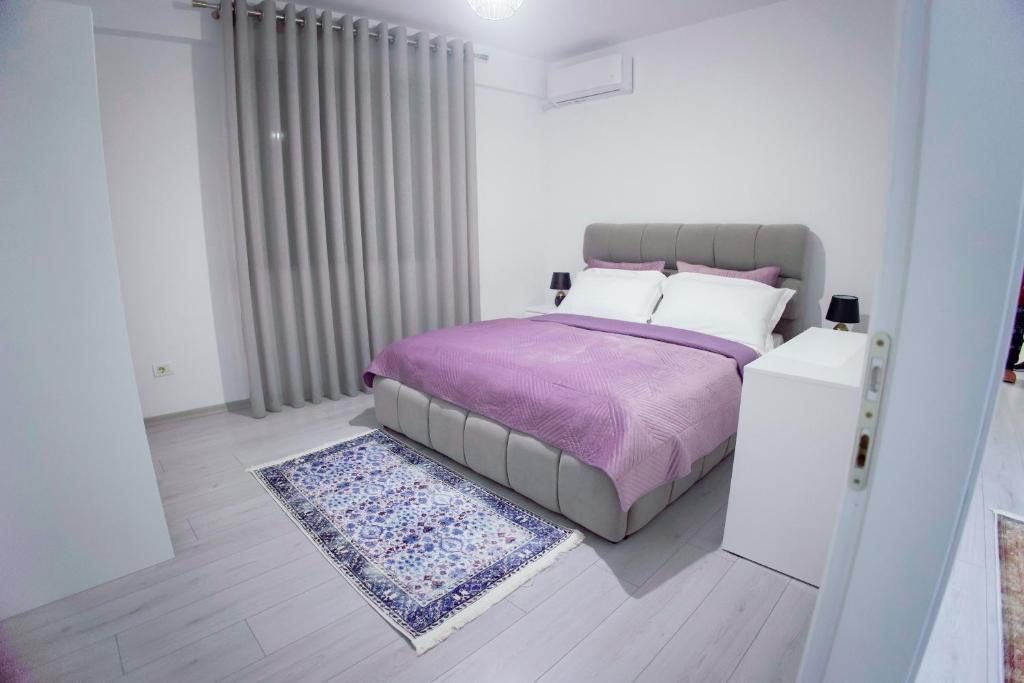 戈里察GRANDE APARTMENT KORCE的一间卧室配有一张带紫色毯子和地毯的床。