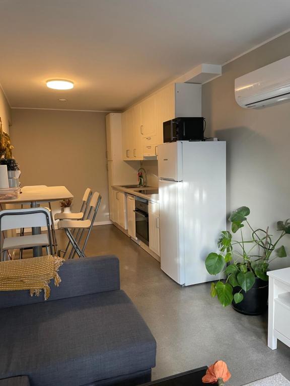 莫斯Ny Hybel leilighet med eget bad og egen inngang的厨房配有白色冰箱和桌子