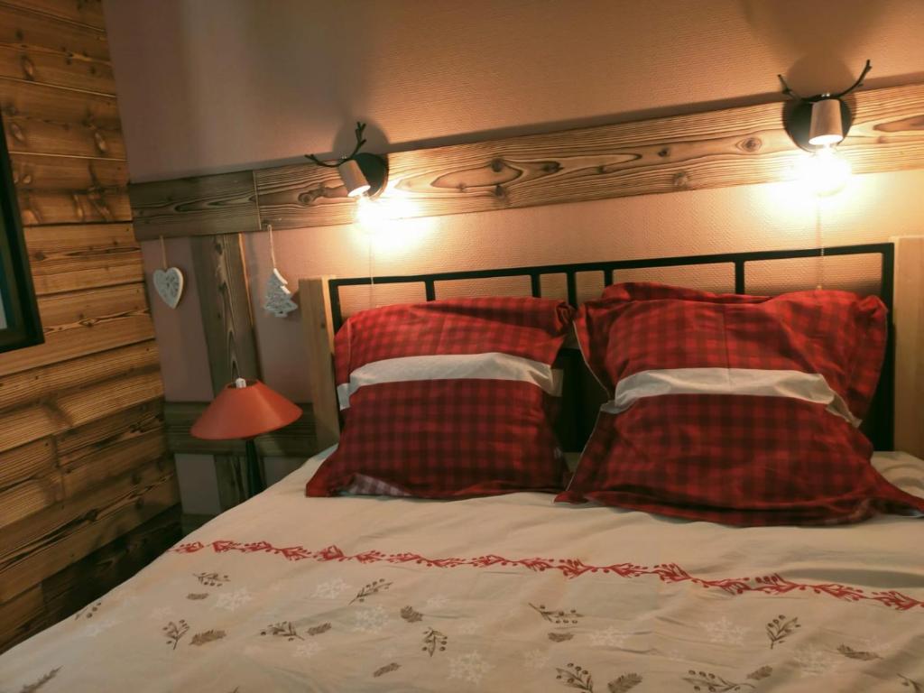 莱代塞尔Fleurs des Alpes的一间卧室配有红色和白色枕头的床