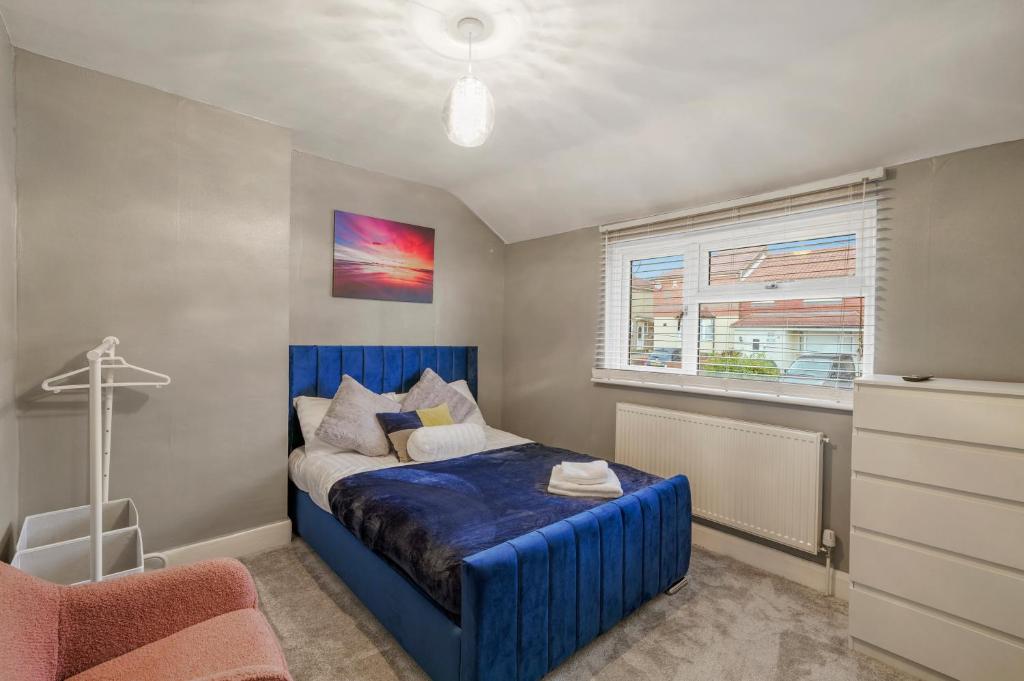 斯特鲁德Cosy home in Rochester, sleeps 6的一间卧室设有蓝色的床和窗户。