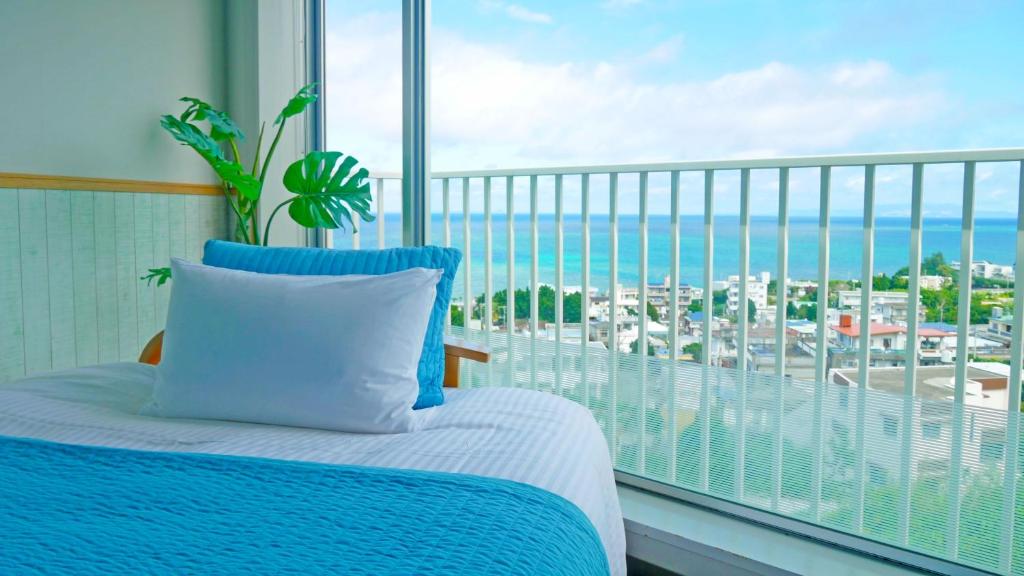 读谷村珊瑚花园七池酒店的一间卧室配有一张床,享有海景