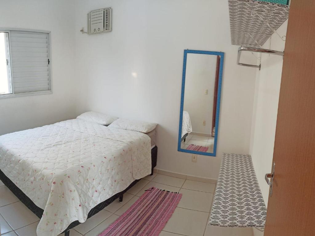 库亚巴Apartamento inteiro próximo à Miguel Sutil的白色卧室配有床和镜子