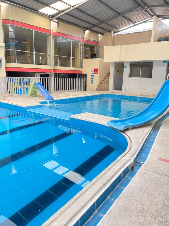 奥塔瓦洛Hostal y Complejo Recreacional La Playita de Monse的一个带滑梯的大型游泳池