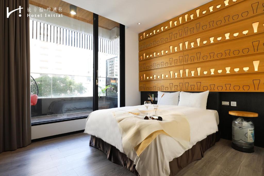 台南旅幸福 - 啤酒花的一间卧室设有一张大床和一个窗户。