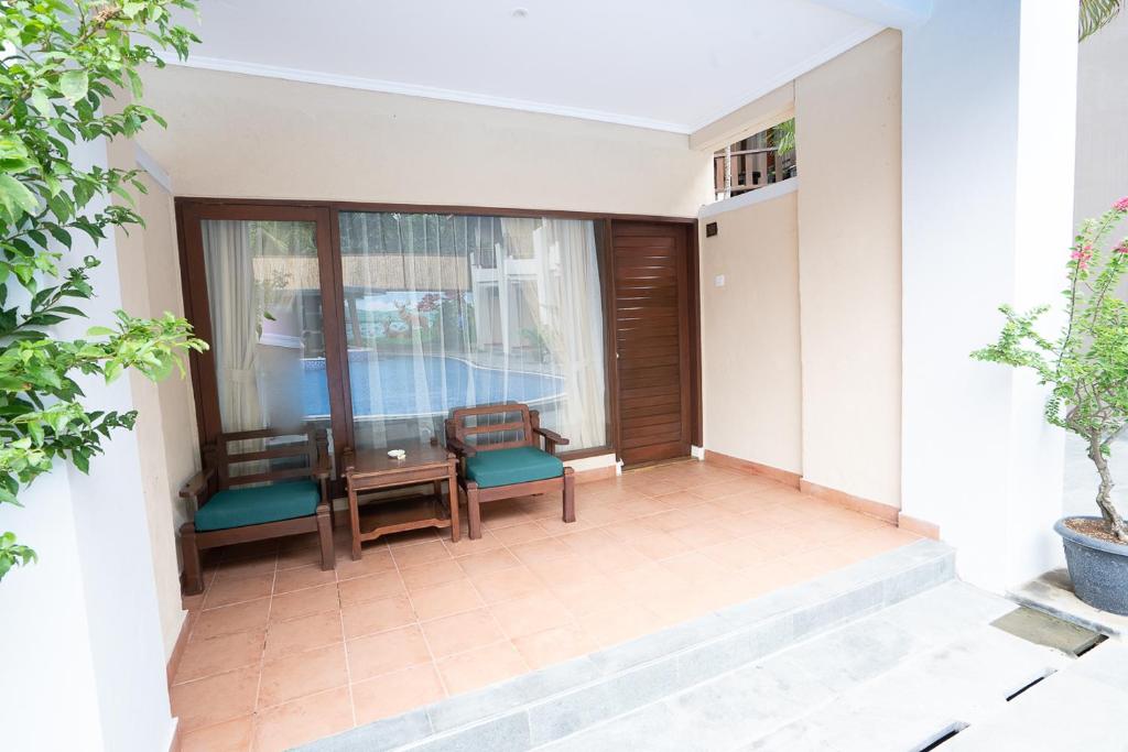 罗威那New Sunari Lovina Beach Resort的阳台配有桌椅和窗户。