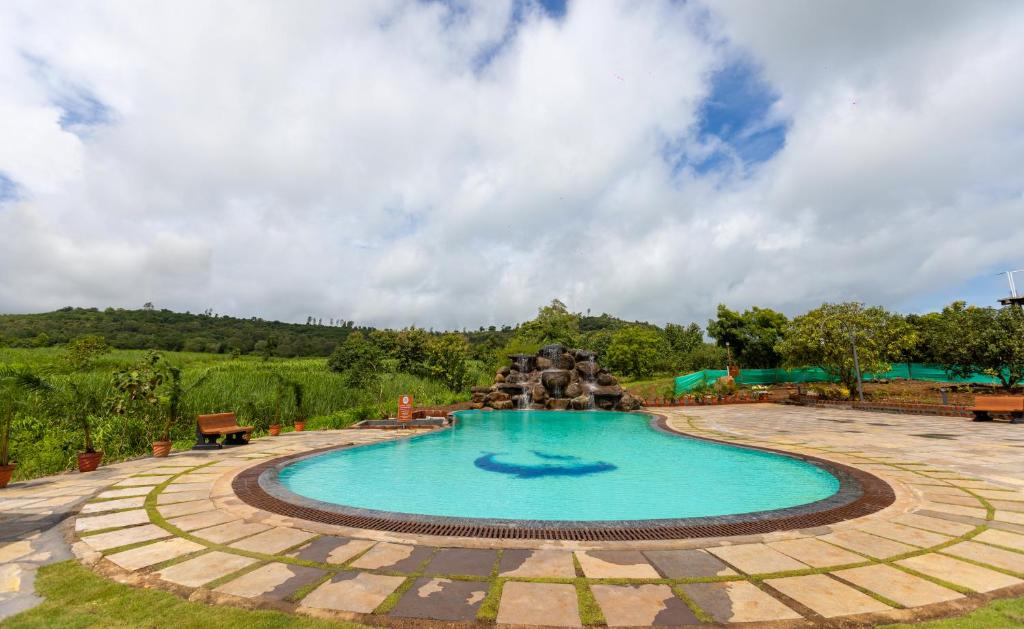 PanhālaAATHAVAN MATICHI ECO RESORT的庭院中一个带喷泉的游泳池