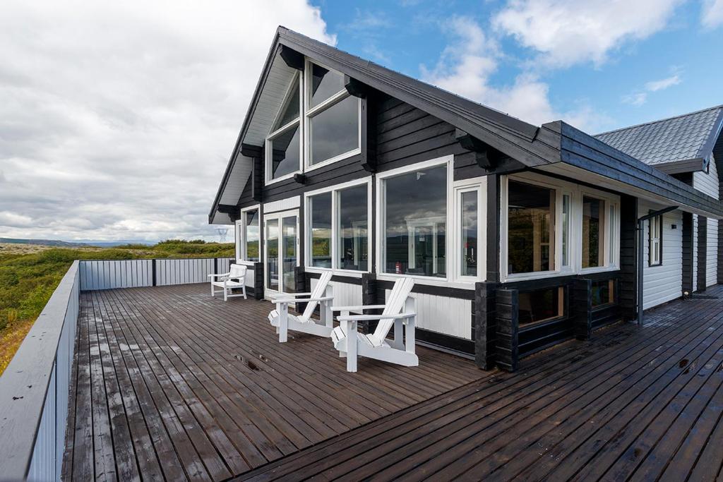 塞尔福斯Blue Viking Luxury Cabin的木制甲板上配有白色椅子的房子