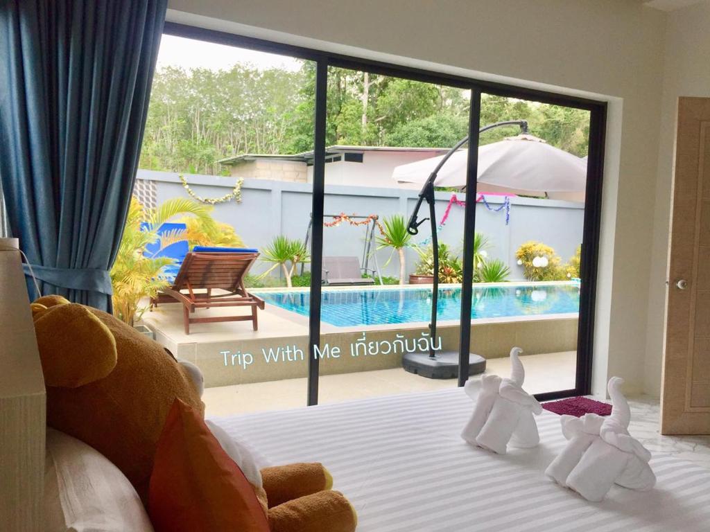 甲米镇Siri Nathai Pool Villa สิรินาไทย พูลวิลล่า的一间卧室设有一张床,享有游泳池的景色