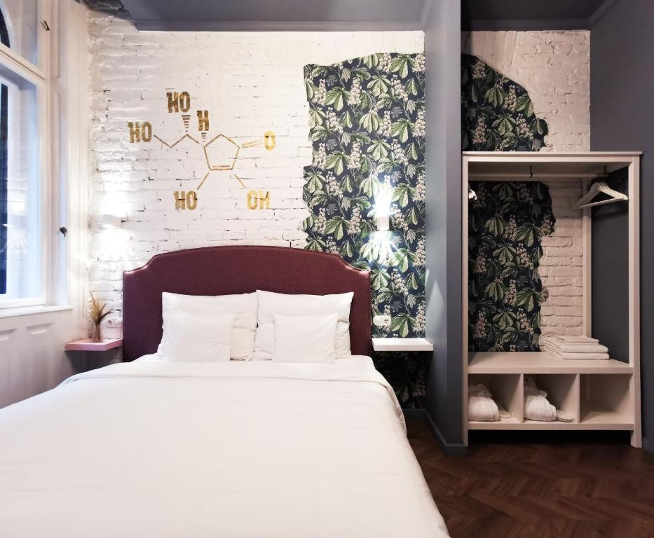 布达佩斯Metropolis Budapest Boutique Hotel的卧室配有白色的床和砖墙
